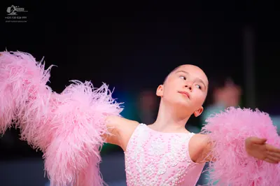Dancesport competitor: Female dancer: light pink costume with pearl or sequin embellishments on the bod