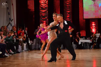 Dancesport competitor: Male dancer: black long-sleeved shirt with a large white collar and black trouse