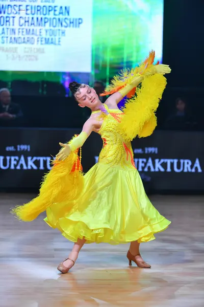 Dancesport competitor: Female dancer: bright yellow ballroom dress with a sequined bodice and a large, 