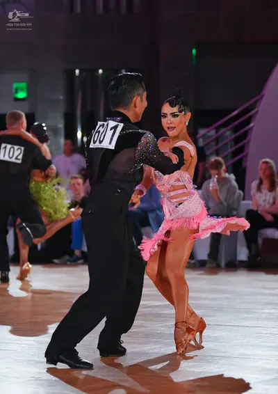 Dancesport competitor #1601, #102: Male dancer (foreground): black shirt with sequins on the upper part and black t