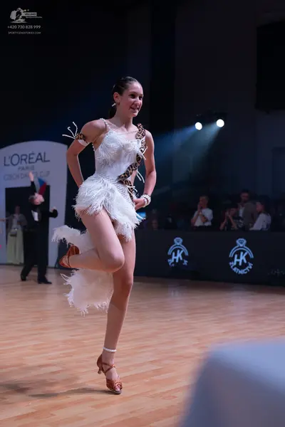 Dancesport competitor: Female dancer: white latin dress with white fringe and leopard print accents, ac