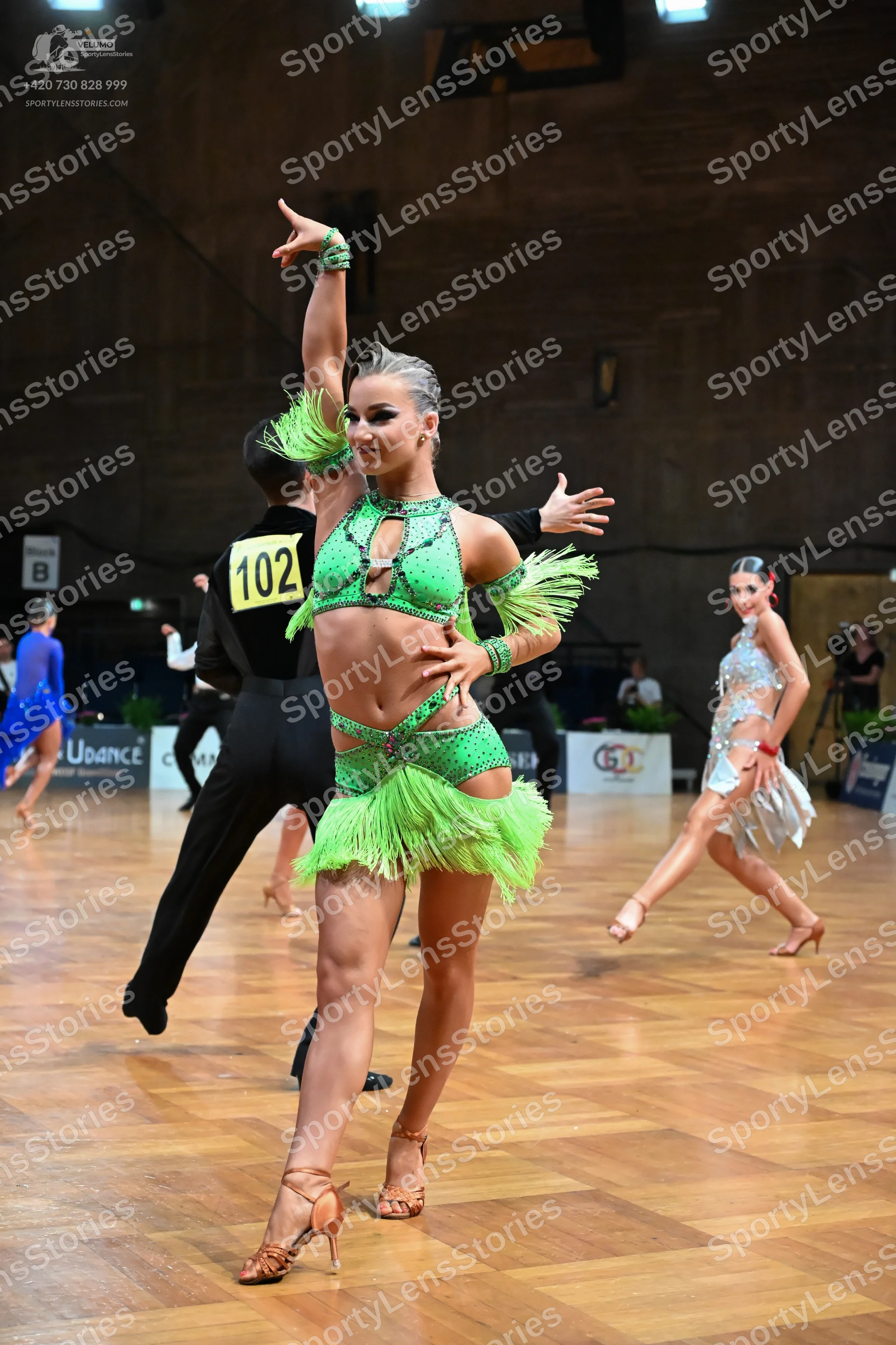 Dancesport competitor #102: Female dancer (foreground): lime green Latin dance costume with fringe and sequi