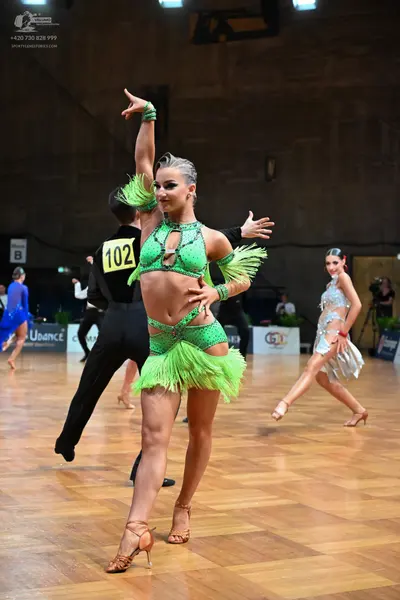 Dancesport competitor #102: Female dancer (foreground): lime green Latin dance costume with fringe and sequi