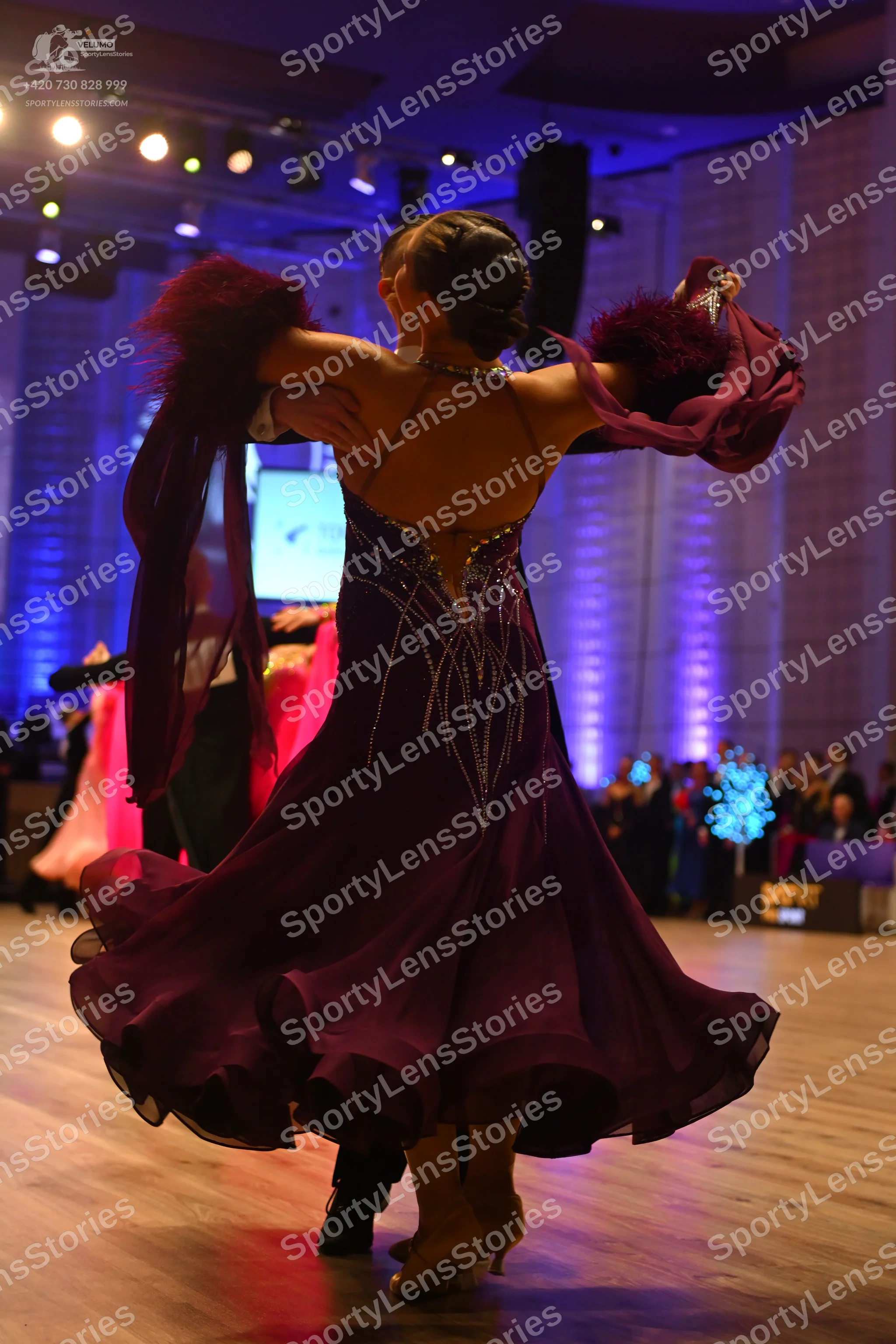 Dancesport competitor: Female dancer: deep purple ballroom dress with silver rhinestone embellishments