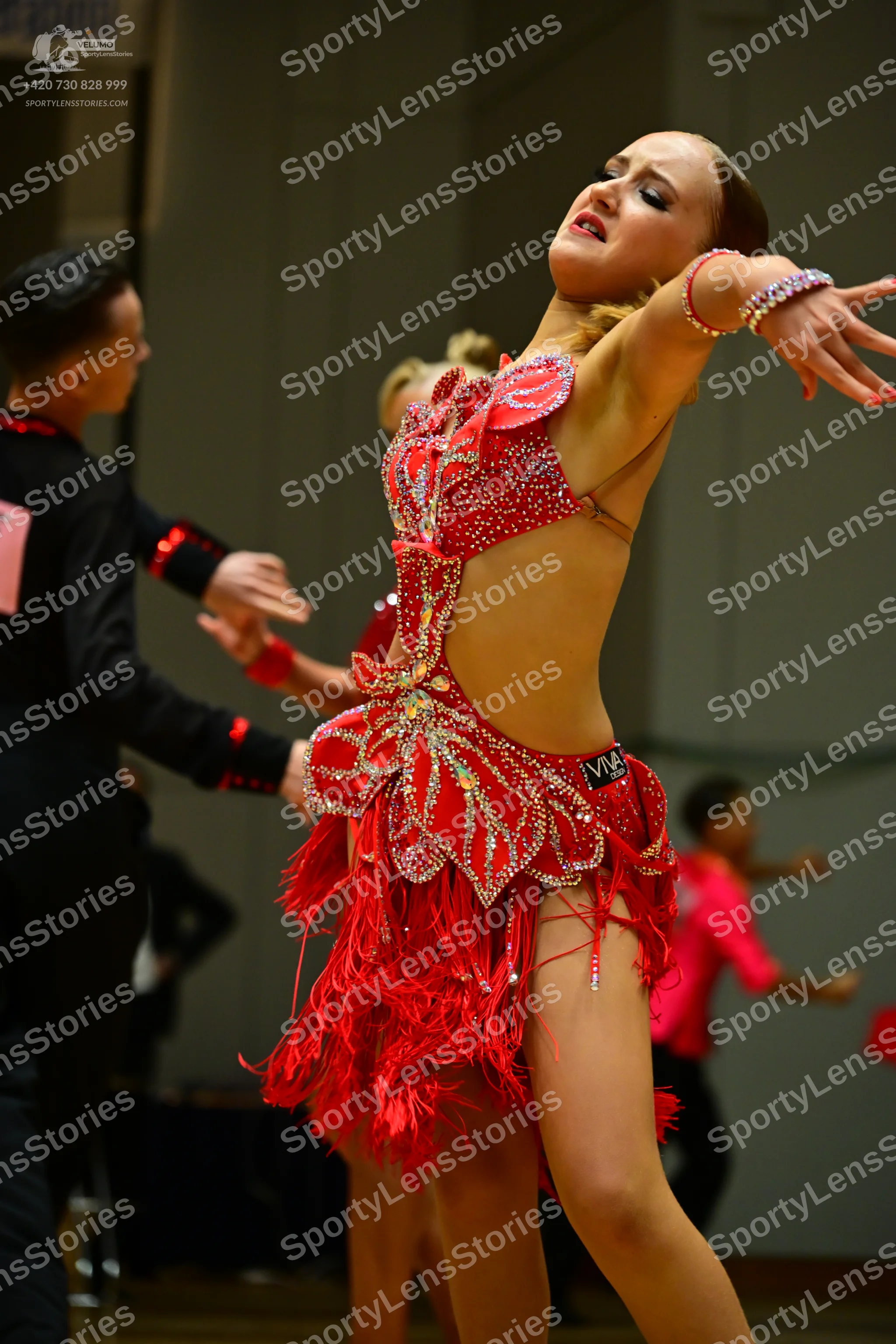Dancesport competitor: Male dancer: black long-sleeve shirt with red sequin accents on the cuffs