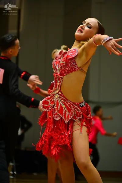 Dancesport competitor: Male dancer: black long-sleeve shirt with red sequin accents on the cuffs