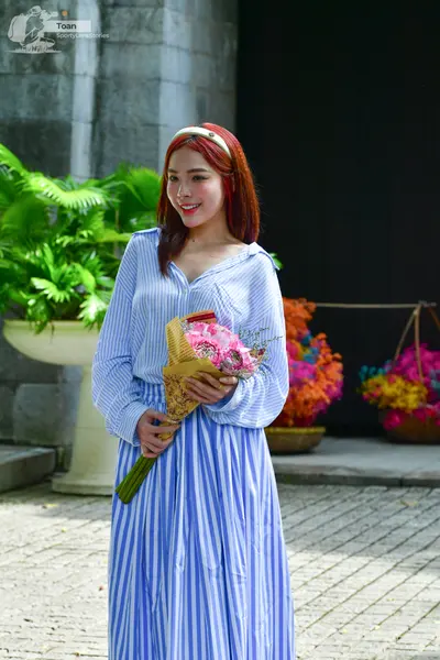 Dancesport competitor: Female dancer: blue and white vertically striped long-sleeved dress with a light