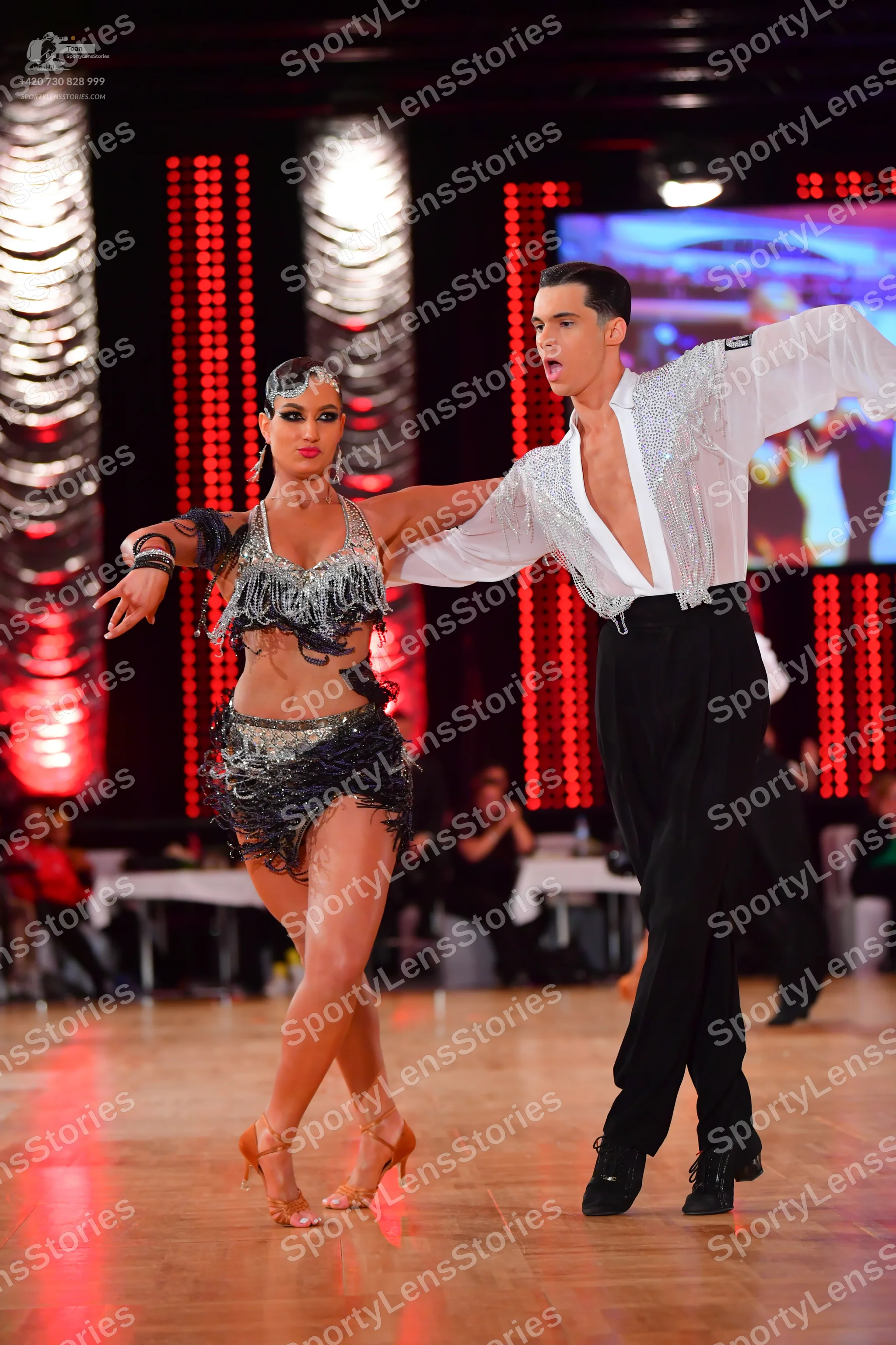 Dancesport competitor: Female dancer: black and silver latin dance costume featuring sequins and long f