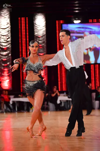 Dancesport competitor: Female dancer: black and silver latin dance costume featuring sequins and long f