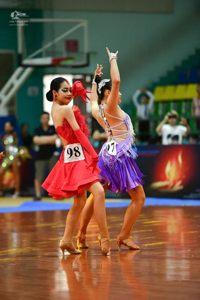 Dancesport competitor #98: ** Red Latin dress
*   **Color:** Primarily red
*   **Fabric:** Satin, likely wi