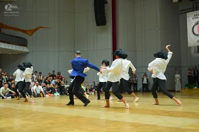 Dancesport competitor: All dancers are wearing matching costumes consisting of white long-sleeved shirt