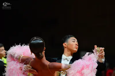 Dancesport competitor: Female dancer: nude-colored dress with large, voluminous pink feather accents on