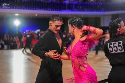 Dancesport competitor #555: Male dancer (center): black long-sleeved dance shirt