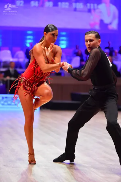 Dancesport competitor: Female dancer: red latin dress with fringe and thin straps