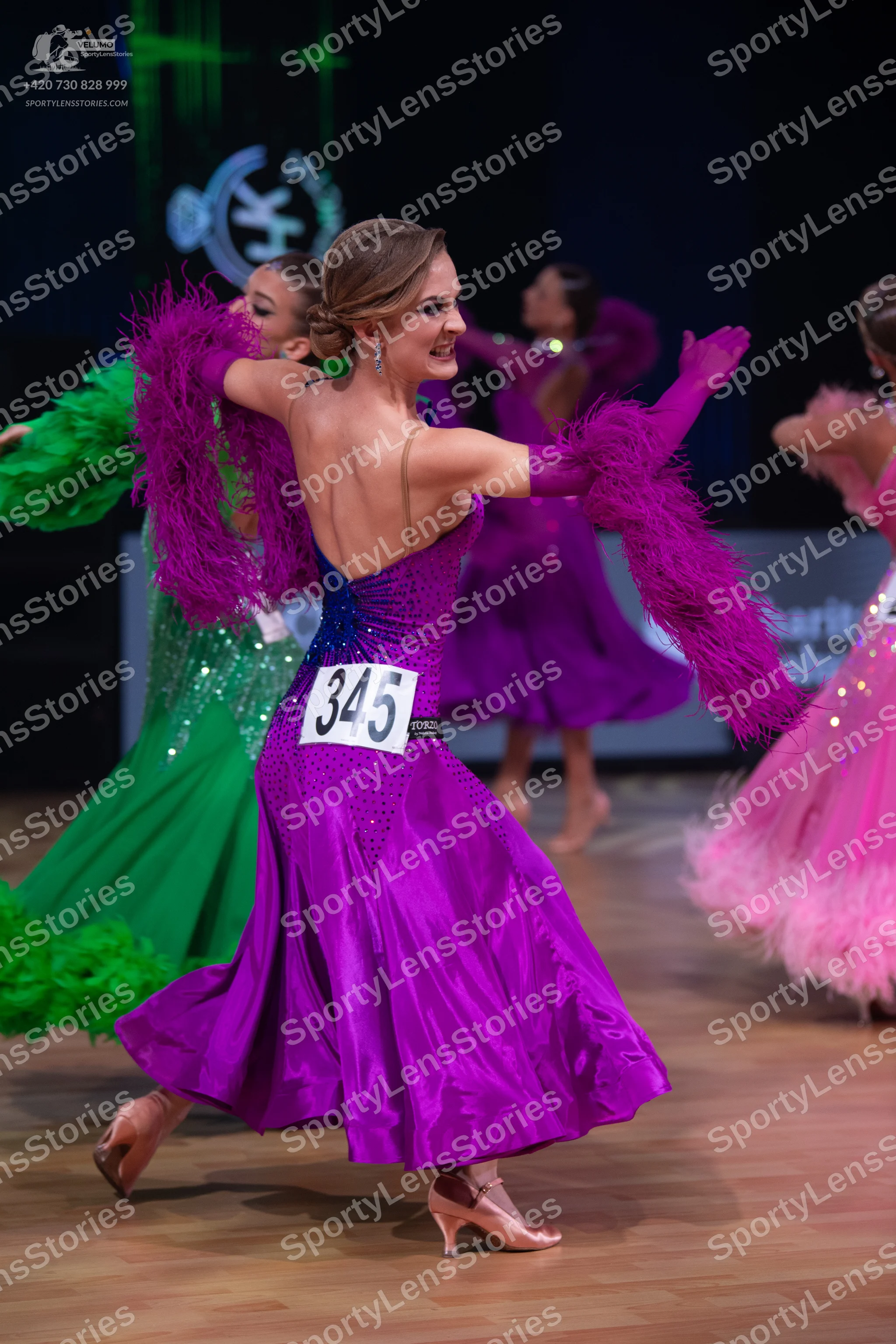 Dancesport competitor: Female dancer (center): purple satin ballroom dress with a blue sequined bodice