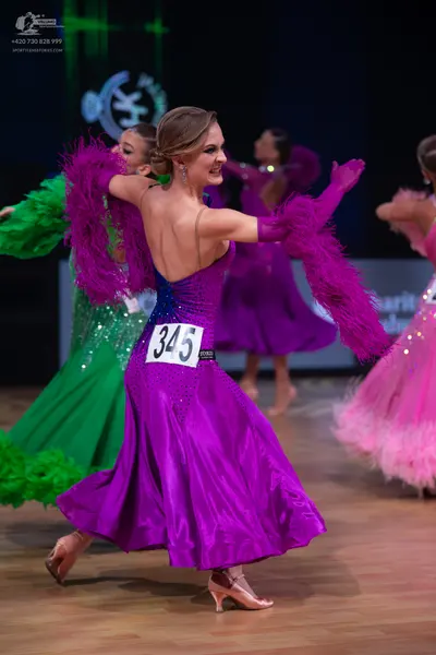 Dancesport competitor: Female dancer (center): purple satin ballroom dress with a blue sequined bodice 