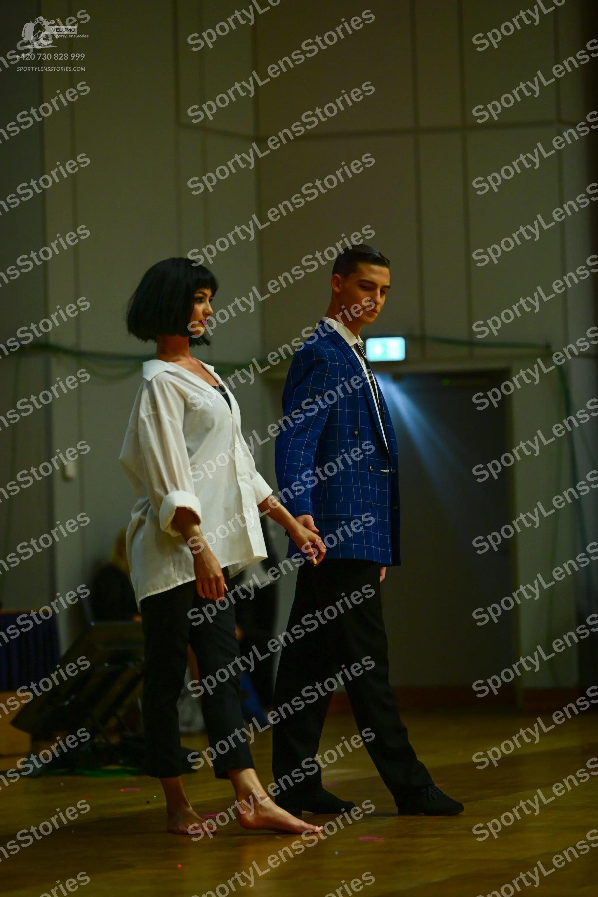 Dancesport competitor: Female dancer: white oversized long-sleeved button-down shirt and black trousers