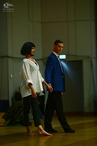 Dancesport competitor: Female dancer: white oversized long-sleeved button-down shirt and black trousers