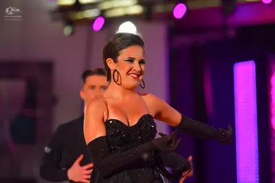 Dancesport competitor: Female dancer: black strapless sequined dress with a sweetheart neckline and lon
