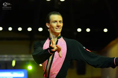 Dancesport competitor: Male dancer: black long-sleeved Latin dance shirt with a sparkly pink sequined f