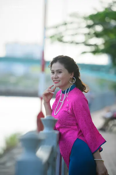 Dancesport competitor: Female dancer: bright pink patterned long-sleeved top with a high collar, dark b