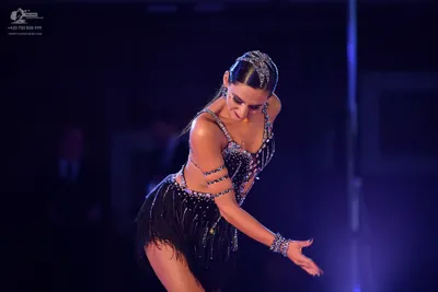Dancesport competitor: Female dancer: black latin dress embellished with silver rhinestones and featuri