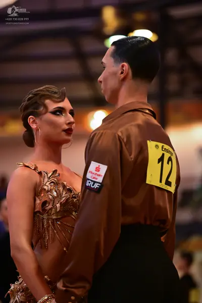 Dancesport competitor #12: Male dancer: brown satin long-sleeved shirt and black trousers