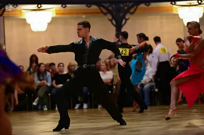 Dancesport competitor: Male dancer: black long-sleeve shirt with satin-like texture and black trousers