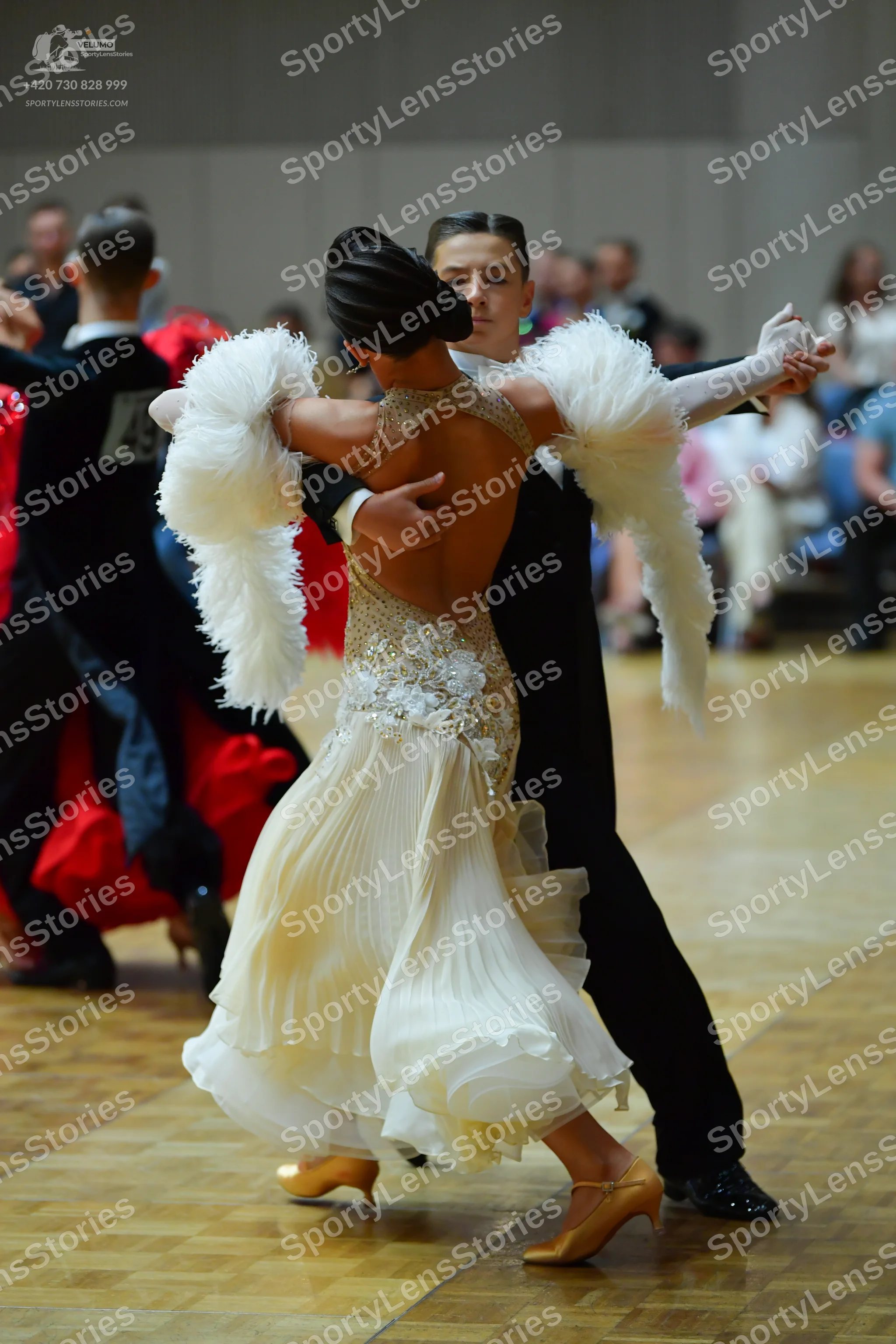 Dancesport competitor: Female dancer: cream-colored ballroom dress with a sequined and beaded bodice, a