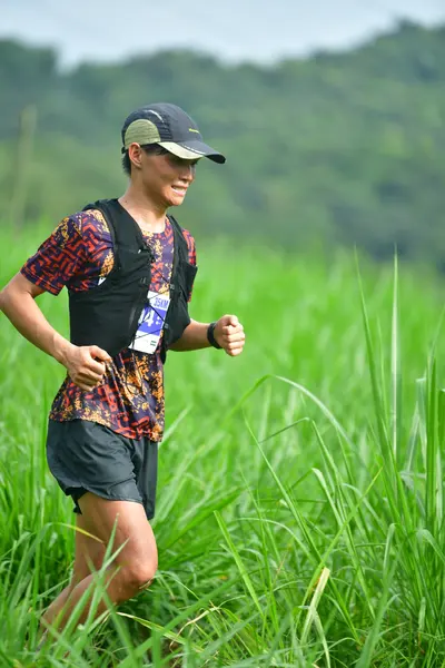 Marathon runner #14: Runner 1: dark patterned shirt, black shorts, dark cap, black watch