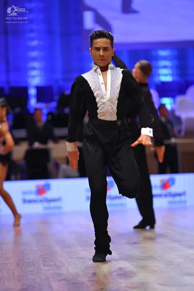 Dancesport competitor: Male dancer: black long-sleeved shirt with a large silver sequined panel on the 