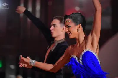 Dancesport competitor: Male dancer: black long-sleeved shirt with subtle embellishments around the neck