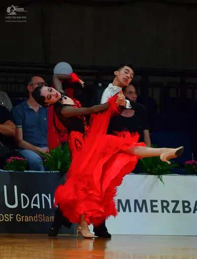Dancesport competitor: Female dancer: red Latin dress with a black bodice and voluminous red fringe