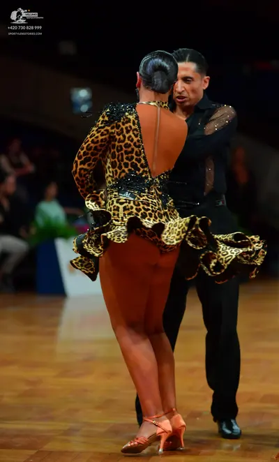 Dancesport competitor: Female dancer: leopard print long-sleeved latin dress with a ruffled skirt and s