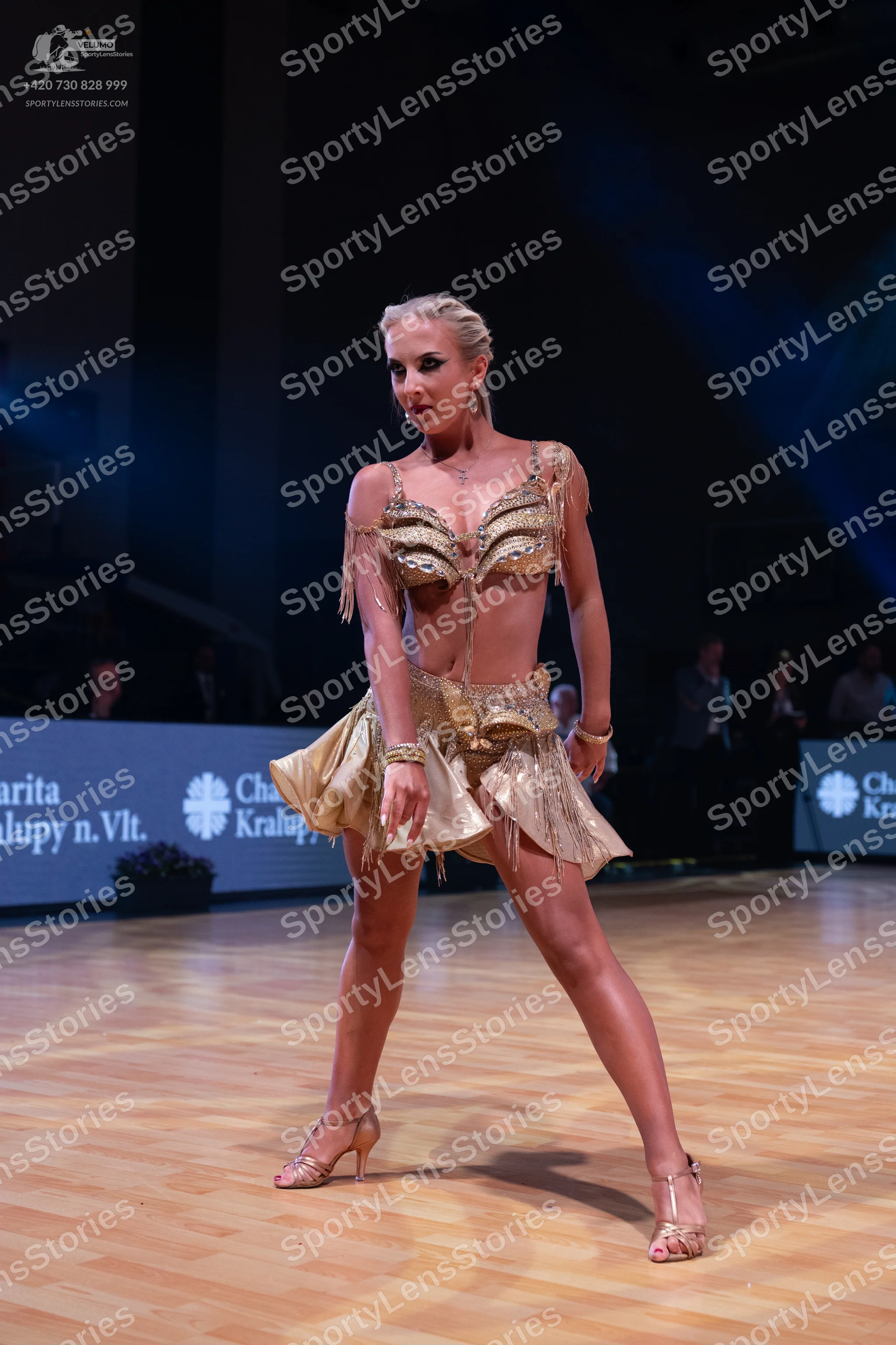 Dancesport competitor: Female dancer: gold/champagne two-piece Latin dance costume featuring sequins/me
