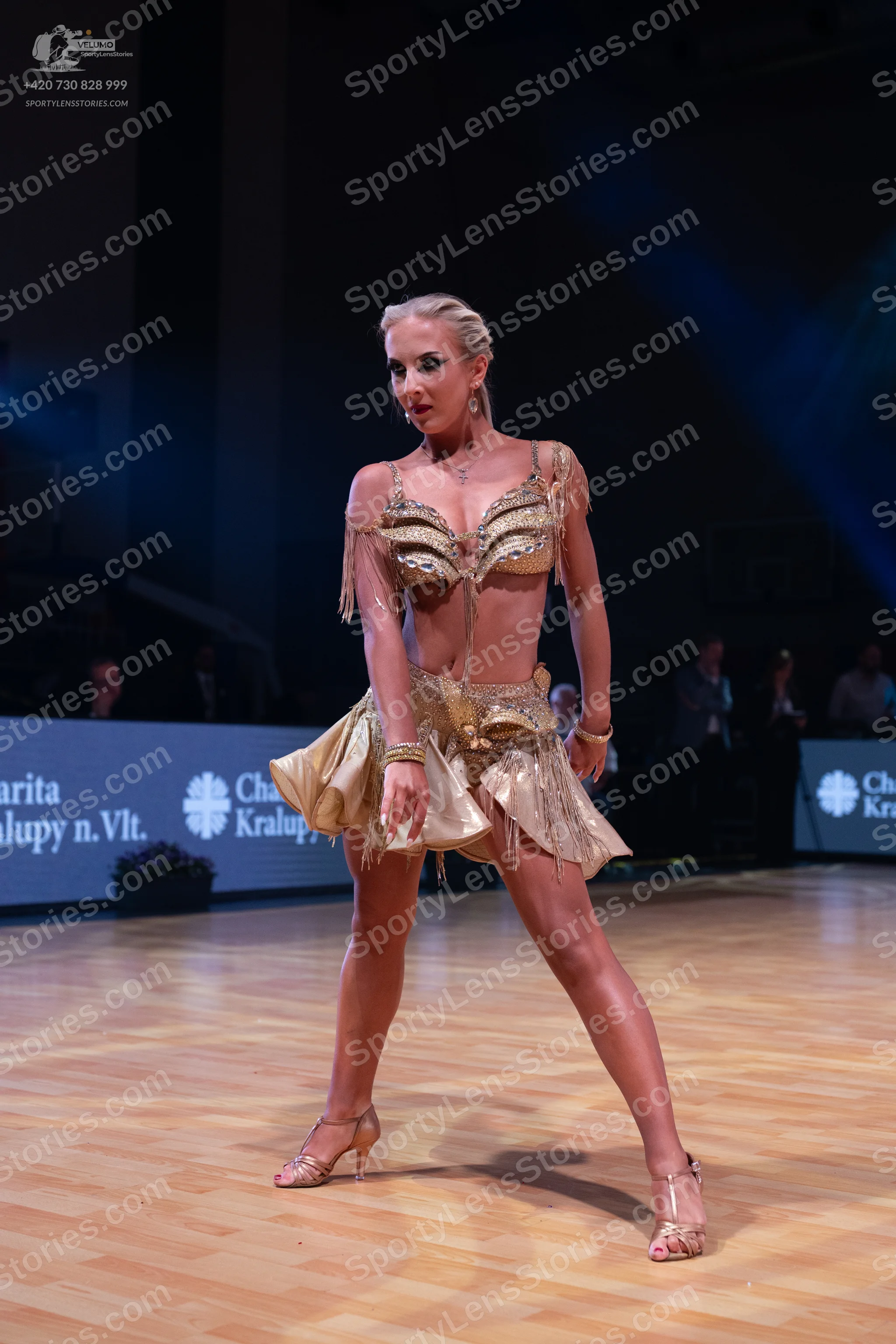 Dancesport competitor: Female dancer: gold/champagne two-piece Latin dance costume featuring sequins/me