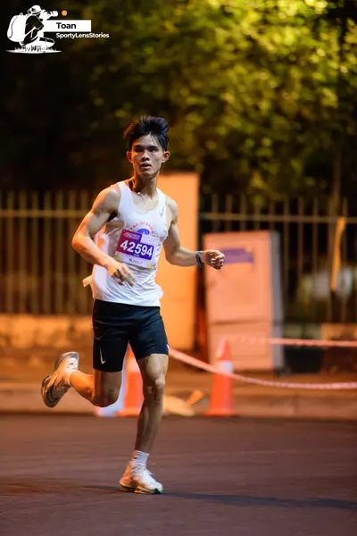 Marathon runner #42594: Runner 1: white tank top, black shorts, white socks, and white/grey running shoe