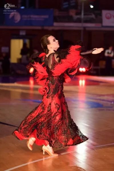 Dancesport competitor: Female dancer: red and black ballroom dress with a large, flowing skirt featurin