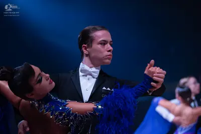 Dancesport competitor: Male dancer: black suit with a white shirt and a white bow tie