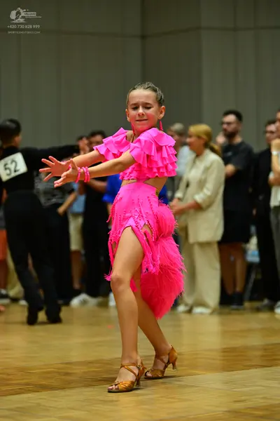 Dancesport competitor #52: Female dancer: bright pink Latin dance dress with ruffled sleeves, a fringe skir