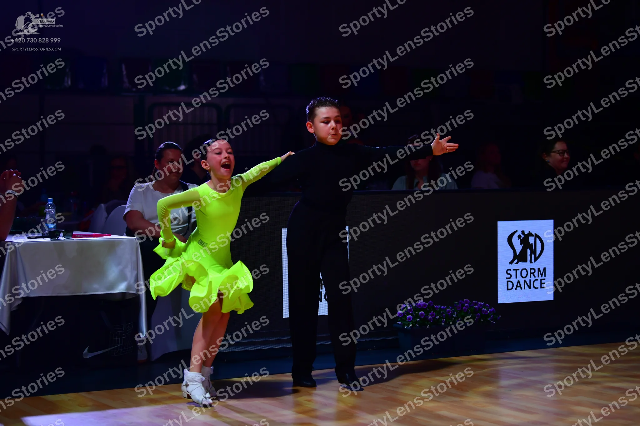 Dancesport competitor: Female dancer: lime green long-sleeved Latin dress with a ruffled skirt