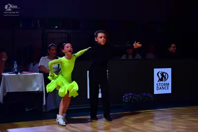 Dancesport competitor: Female dancer: lime green long-sleeved Latin dress with a ruffled skirt