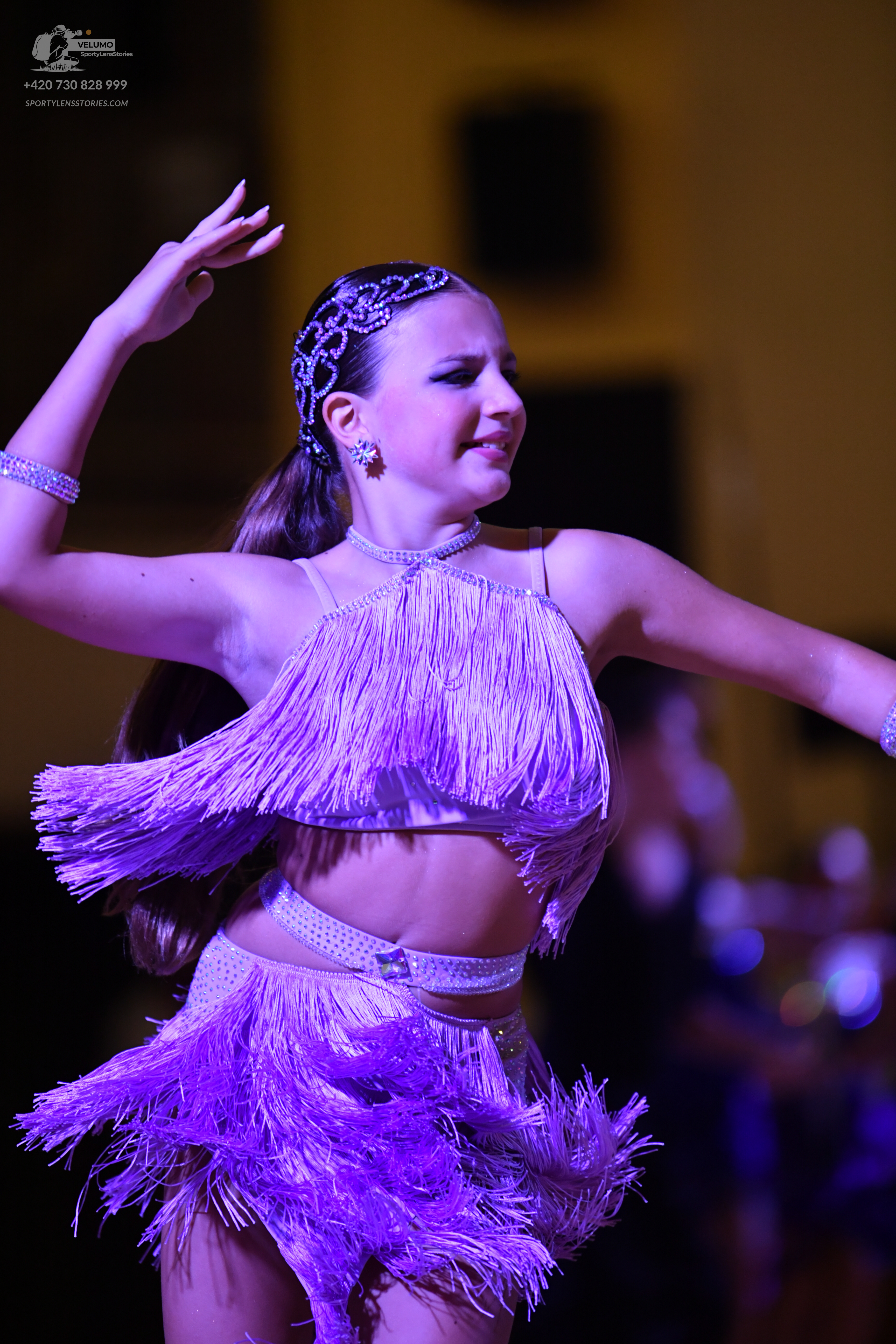 Dancesport competitor: Female dancer: light purple latin dress with fringe, featuring a halter-style cr