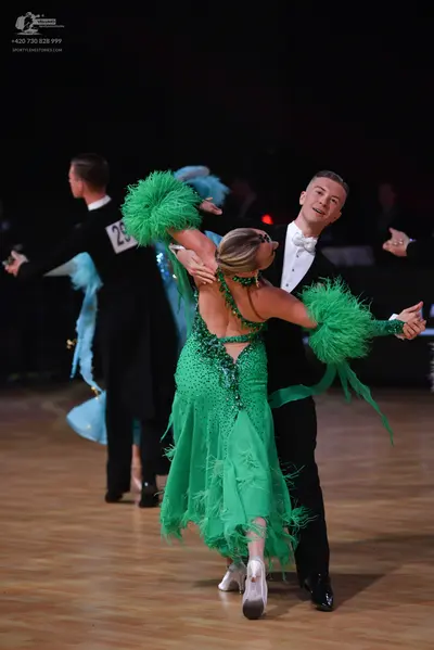 Dancesport competitor: Male dancer (left): black formal suit with a white shirt and black trousers
