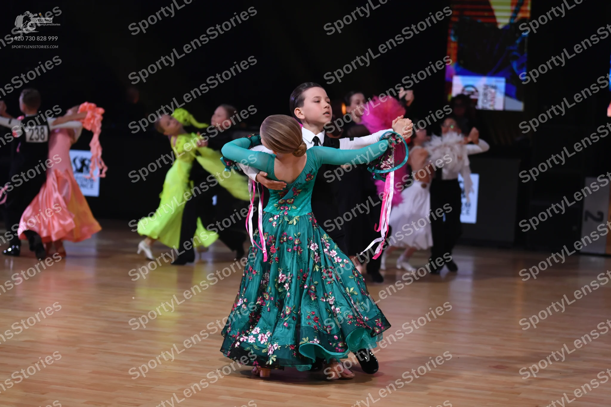 Dancesport competitor: Male dancer (far left): black suit and white shirt