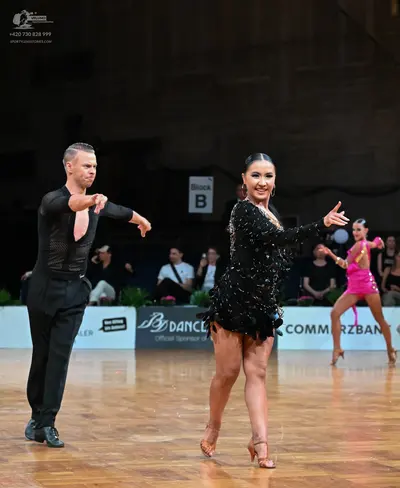 Dancesport competitor: Male dancer: black long-sleeved top with a deep V-neck and black trousers