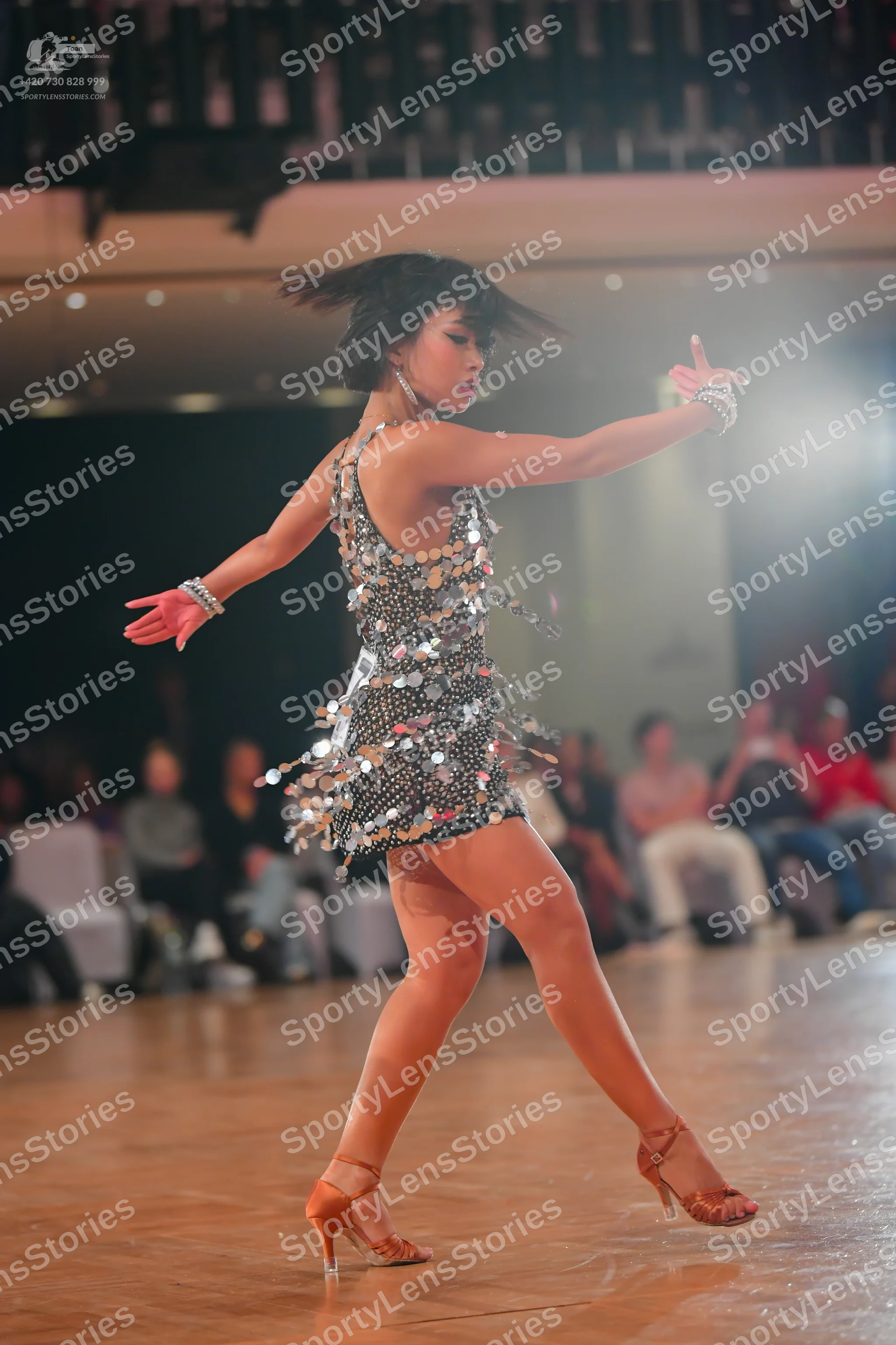 Dancesport competitor: Female dancer: silver sequined latin dress with reflective elements, sleeveless,