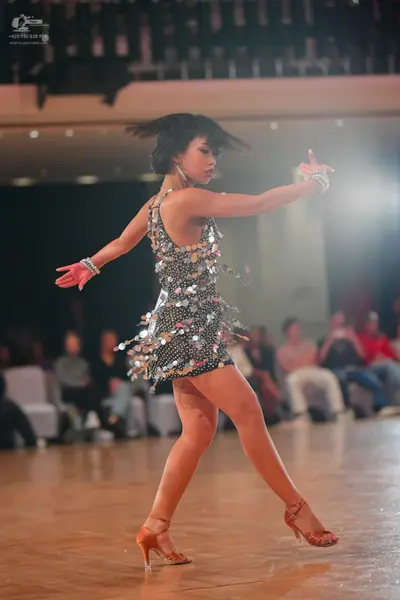 Dancesport competitor: Female dancer: silver sequined latin dress with reflective elements, sleeveless,