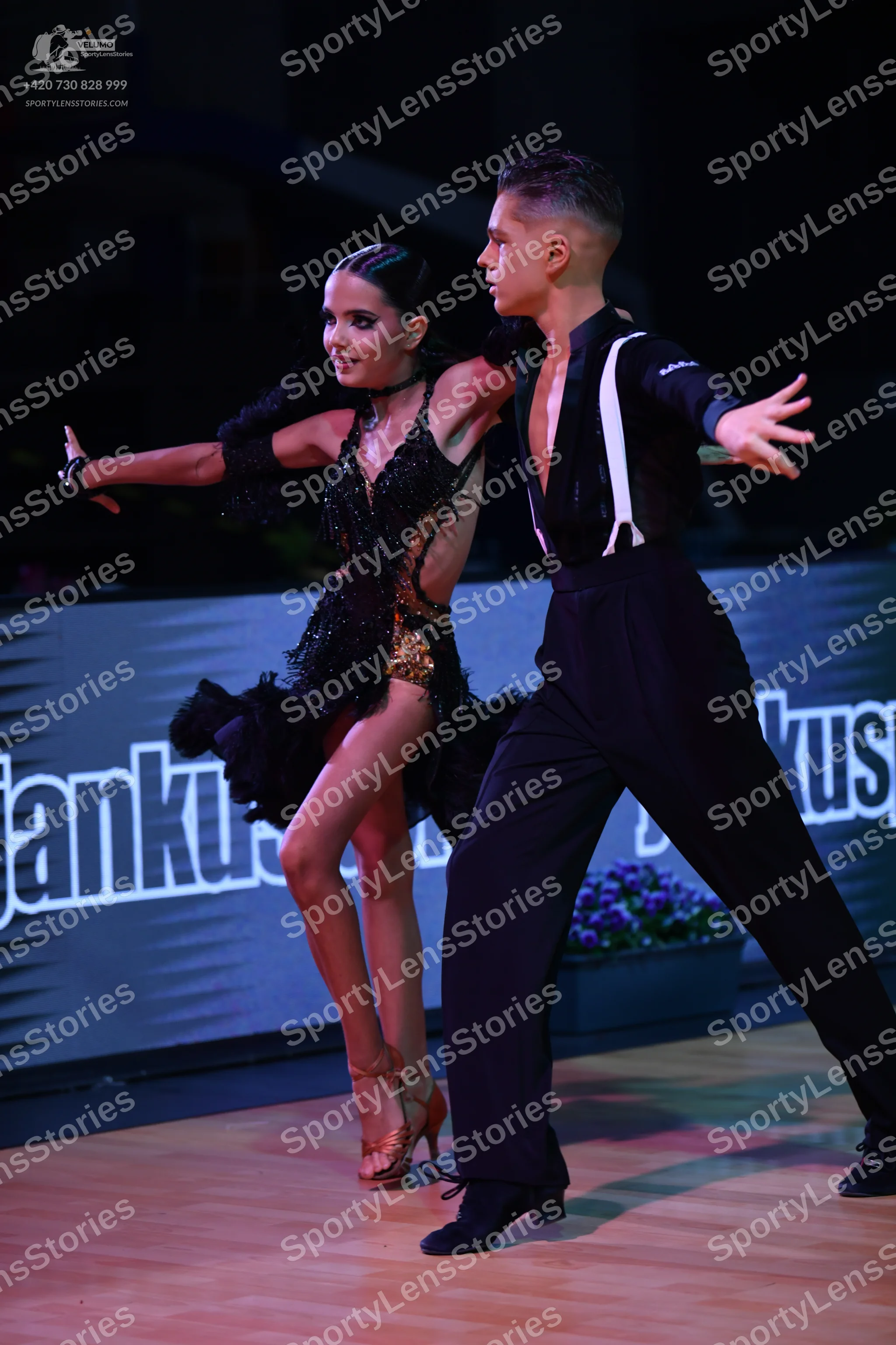 Dancesport competitor: Female dancer: black Latin dance dress with gold sequins and a textured skirt