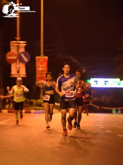 Marathon runner #42479, #42561: Runner 1: lime green sleeveless shirt, black shorts, lime green socks, dark shoe